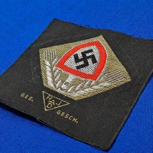 german-world-war-two-labor-cap-insignia-unissued-with-wheat-stalks-and-shovel-bevo-flat-wire-construction