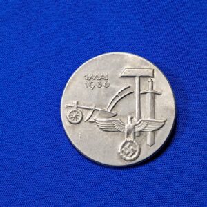 Tinnie May-day WWII 36. Condition excellent. Made of aluminum and maker marked on the reverse. Biedermann & Co. Original pin on the reverse. VERY clean with no oxidation. Never cleaned. This was a festival that celebration the planting of crops and other spring events