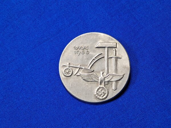 Tinnie May-day WWII 36. Condition excellent. Made of aluminum and maker marked on the reverse. Biedermann & Co. Original pin on the reverse. VERY clean with no oxidation. Never cleaned. This was a festival that celebration the planting of crops and other spring events