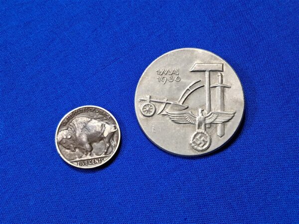 Tinnie May-day WWII 36. Condition excellent. Made of aluminum and maker marked on the reverse. Biedermann & Co. Original pin on the reverse. VERY clean with no oxidation. Never cleaned. This was a festival that celebration the planting of crops and other spring events