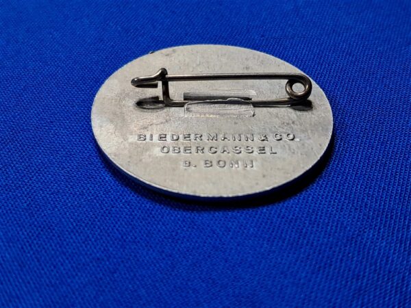 Tinnie May-day WWII 36. Condition excellent. Made of aluminum and maker marked on the reverse. Biedermann & Co. Original pin on the reverse. VERY clean with no oxidation. Never cleaned. This was a festival that celebration the planting of crops and other spring events